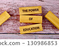 Concept words THE POWER OF EDUCATION is assembled from blocks on wooden boards, top view 130986853