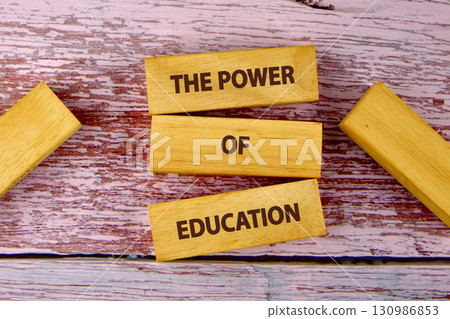 Concept words THE POWER OF EDUCATION is assembled from blocks on wooden boards, top view Concept words THE POWER OF EDUCATION is assembled from blocks on wooden boards, top view 130986853