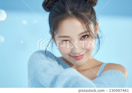 A girl in ballet core fashion with a cute wink on a light blue background 130987461