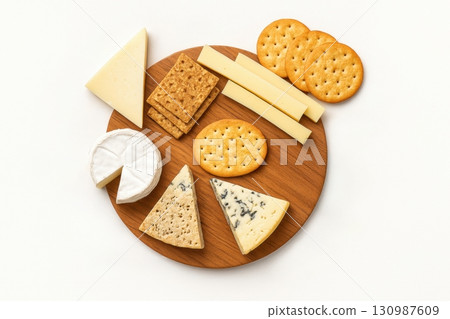 Assorted cheese and crackers on wooden board for appetizer or snack 130987609