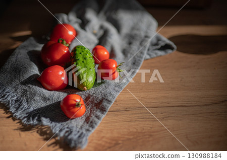 Cucumbers and tomatoes. Washed cucumbers and tomatoes in a towel. 130988184