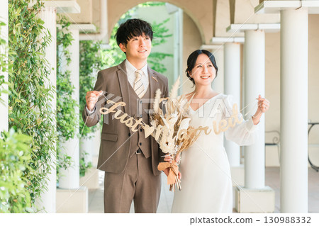 新娘和新郎帶著花環在婚禮大廳（新娘婚禮） 130988332