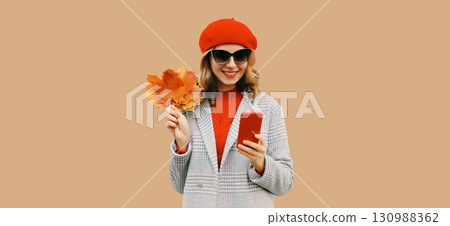 Autumn portrait stylish happy smiling young woman with phone, beautiful girl holding yellow leaves Autumn portrait stylish happy smiling young woman with phone, beautiful girl holding yellow leaves 130988362