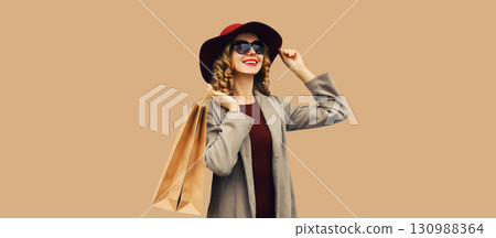 Autumn portrait of beautiful young woman with shopping bag, stylish girl in coat on brown background 130988364