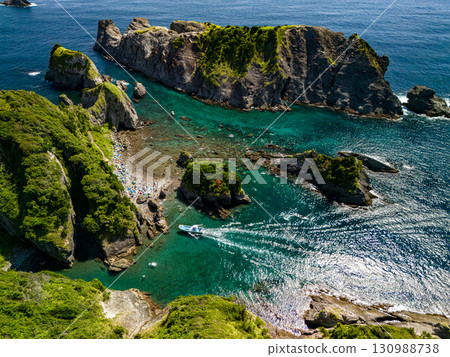 正在進行航拍,以勘察Hirizo海灘及其周圍的島嶼和海域。無人機的飛行得到了當地漁業協會的許可。 正在進行航拍,以勘察Hirizo海灘及其周圍的島嶼和海域。無人機的飛行得到了當地漁業協會的許可。 130988738