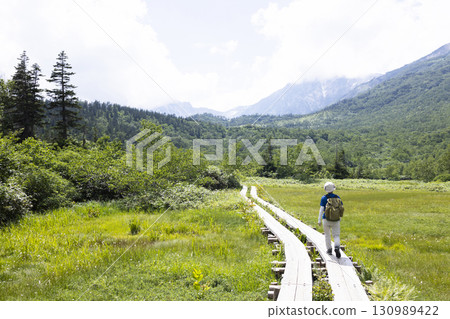 Woman hiking on a boardwalk Woman hiking on a boardwalk 130989422