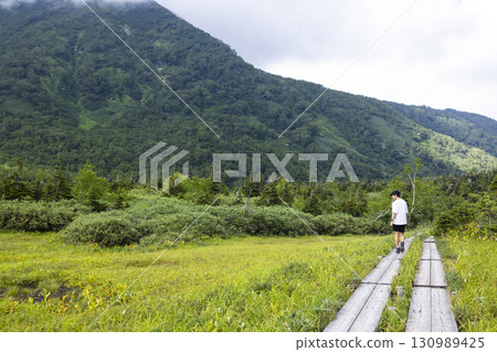 一名男子在木板路上健行 130989425