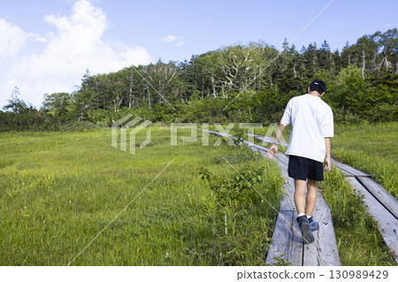 Man hiking on a boardwalk 130989429