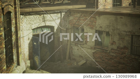 Sunlight filters through the cracked walls of an old factory, revealing the textures of decay. Shadows stretch across the weathered bricks, inviting exploration of forgotten history. Sunlight filters through the cracked walls of an old factory, revealing the textures of decay. Shadows stretch across the weathered bricks, inviting exploration of forgotten history. 130989968