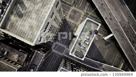 From above, a vibrant cityscape reveals a web of roads and towering buildings. The structured chaos of traffic showcases the dynamic energy of urban life, highlighting distinctive architecture. From above, a vibrant cityscape reveals a web of roads and towering buildings. The structured chaos of traffic showcases the dynamic energy of urban life, highlighting distinctive architecture. 130989969