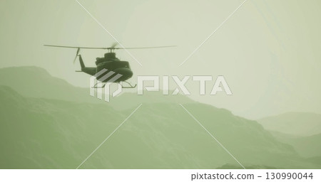 A helicopter gracefully flies above soft, rolling mountains during early morning light. Mist lingers in the valleys, creating a serene and peaceful atmosphere in this breathtaking landscape. 130990044