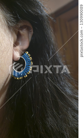 Handmade beaded and bugle bead earrings on a girl's ear. Product demonstration. Handmade beaded and bugle bead earrings on a girl's ear. Product demonstration. 130990089