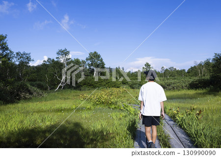 Man hiking on a boardwalk Man hiking on a boardwalk 130990090