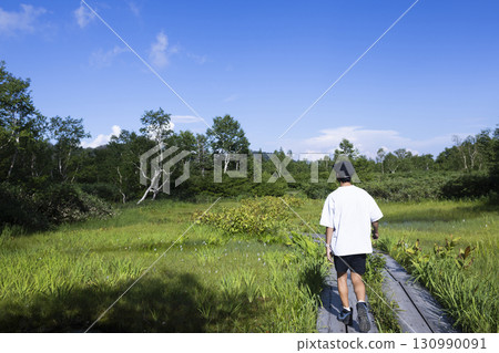 Man hiking on a boardwalk 130990091