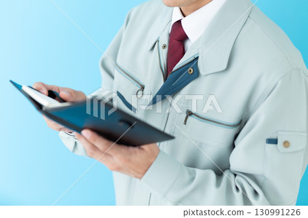 一位身穿工作服的中年男性商人正在看筆記本 130991226