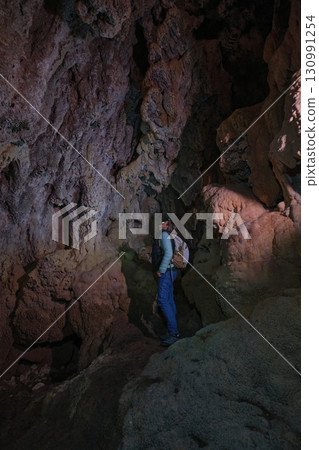 Man in a cave with a flashlight on his head 130991254