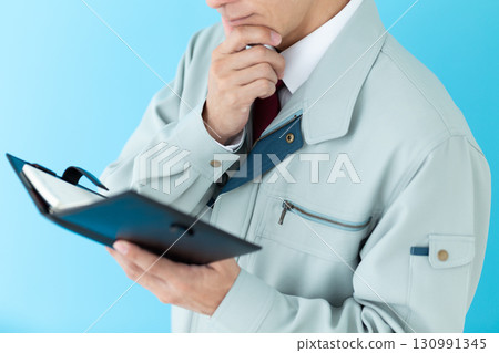 A middle-aged male businessman in work clothes worried about his notebook 130991345