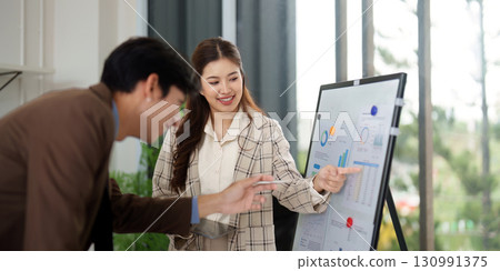 Data Presentation. Business professionals discussing analytics on a presentation board. 130991375