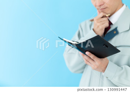 A middle-aged male businessman in work clothes worried about his notebook 130991447