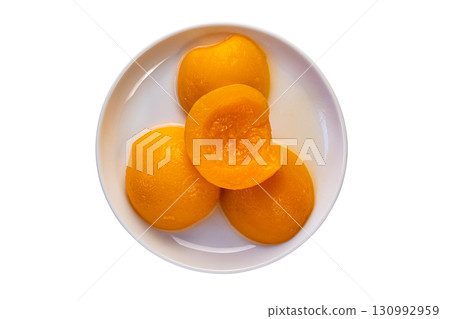 Top view of canned peach halves in syrup in white ceramic plate. Top view of canned peach halves in syrup in white ceramic plate. 130992959