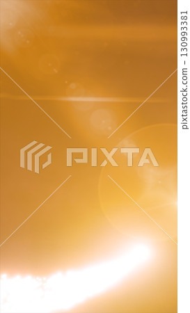 Bright golden lens flare and sunburst effect creating soft glowing orbs on an amber background Bright golden lens flare and sunburst effect creating soft glowing orbs on an amber background 130993381