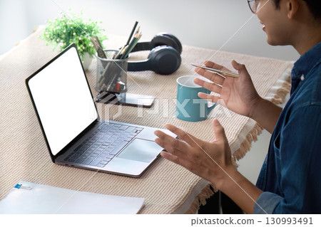 Work from Home. Engaged professional participating in a virtual meeting with laptop and coffee. 130993491