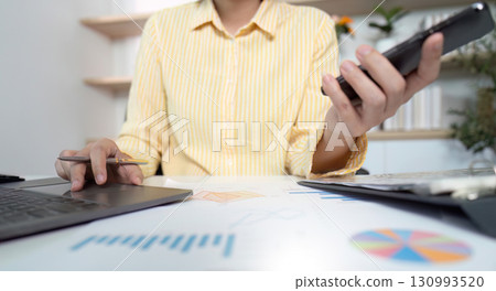 Business Analysis. Professional multitasking with phone and laptop in office. 130993520