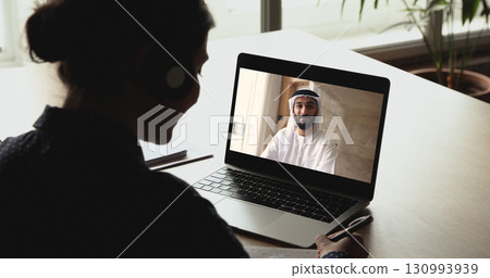 Arabian man leading on-line talk to Indian female colleague Arabian man leading on-line talk to Indian female colleague 130993939