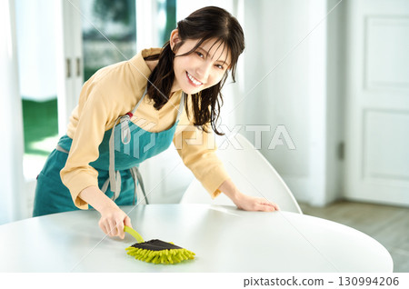 Housewife in an apron cleaning 130994206