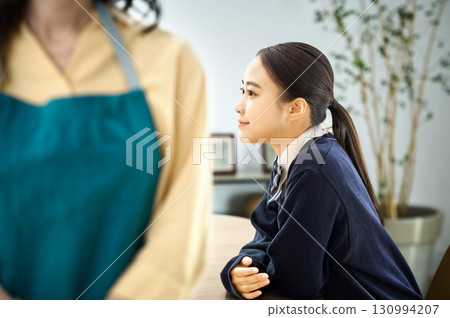 A mother in an apron and her daughter in a uniform 130994207