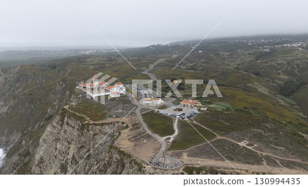 A breathtaking aerial view showcasing a coastal lighthouse and the captivating surrounding landscape A breathtaking aerial view showcasing a coastal lighthouse and the captivating surrounding landscape 130994435