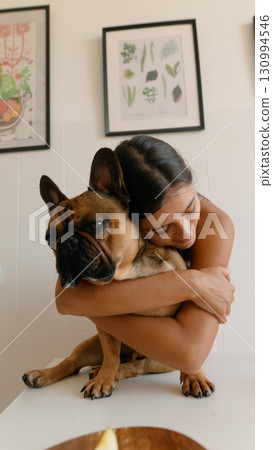 A heartwarming scene of a dog and owner joyfully embracing in a cozy, decorated home 130994546