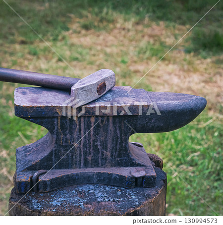 heavy hammer on iron anvil, traditional forge 130994573