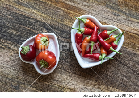 hot peppers lanterns chili red stacked in a plate heart shape view from top on wooden background 130994607