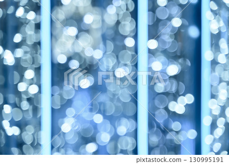 Blurred abstract background image glowing blue and white bokeh lights with vertical light bars Blurred abstract background image glowing blue and white bokeh lights with vertical light bars 130995191