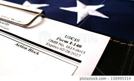 I-140 Immigrant petition for alien workers blank form lies on American Flag background I-140 Immigrant petition for alien workers blank form lies on American Flag background 130995314