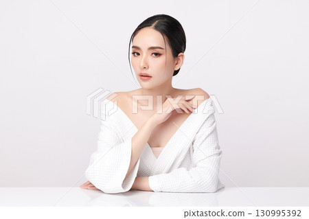 A beautiful young Asian woman with clean, fresh skin against a white background. Skincare, facial treatment, cosmetology, beauty, and spa. An elegant portrait of an Asian woman. 130995392