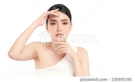 A beautiful young Asian woman with clean, fresh skin against a white background. Skincare, facial treatment, cosmetology, beauty, and spa. An elegant portrait of an Asian woman. 130995395