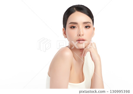 A beautiful young Asian woman with clean, fresh skin against a white background. Skincare, facial treatment, cosmetology, beauty, and spa. An elegant portrait of an Asian woman. 130995398