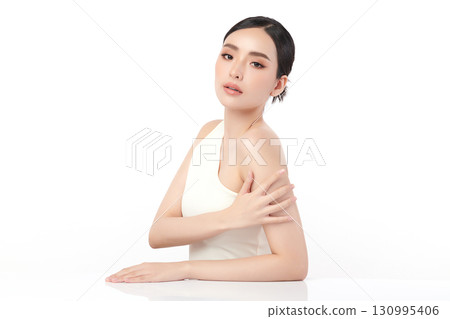 A beautiful young Asian woman with clean, fresh skin against a white background. Skincare, facial treatment, cosmetology, beauty, and spa. An elegant portrait of an Asian woman. 130995406