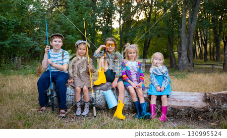 Five smiling children in rubber boots and bright clothing posing outdoors Five smiling children in rubber boots and bright clothing posing outdoors 130995524