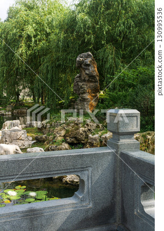 scholar rock on the shore of a pond in traditional Chinese garden scholar rock on the shore of a pond in traditional Chinese garden 130995536