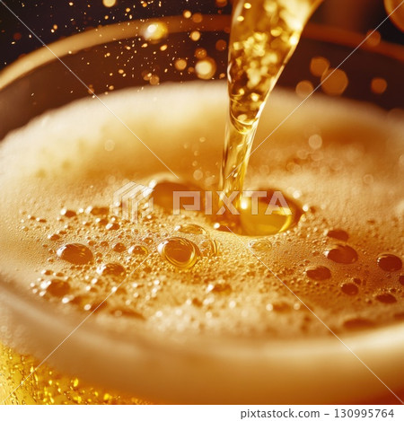 Close-up of golden beer pouring into a glass with bubbles 130995764