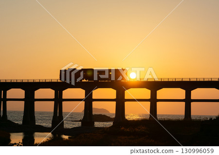 夕陽映照下的崇光川大橋上行駛的電車 夕陽映照下的崇光川大橋上行駛的電車 130996059