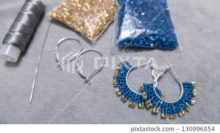 Handmade beaded and glass bead earrings on a light background. Copy space Handmade beaded and glass bead earrings on a light background. Copy space 130996854