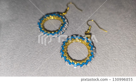 Handmade beaded and glass bead earrings on a light background. Copy space 130996855