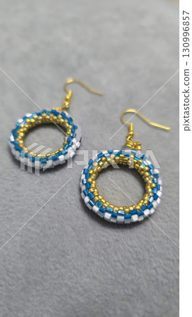 Handmade beaded and glass bead earrings on a light background. Copy space 130996857
