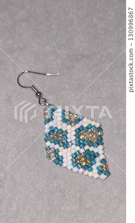 Handmade beaded and glass bead earrings on a light background. Copy space 130996867