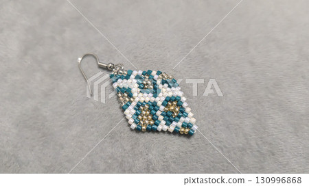 Handmade beaded and glass bead earrings on a light background. Copy space Handmade beaded and glass bead earrings on a light background. Copy space 130996868