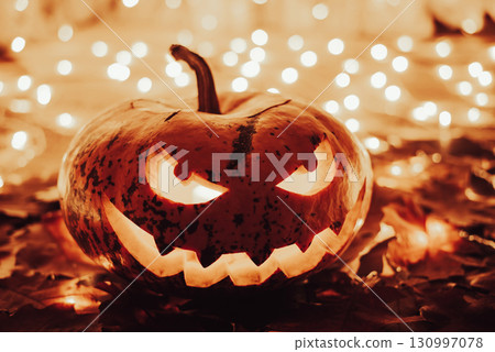Indoors shot of a jack-o-lantern made for celebrating halloween. Creative creepy face pumpkin with bright lights around Indoors shot of a jack-o-lantern made for celebrating halloween. Creative creepy face pumpkin with bright lights around 130997078